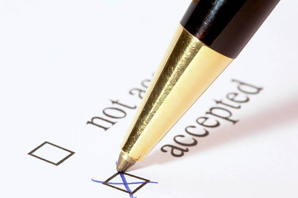 Photo gros plan sur la pointe d'un stylo cochant une case "accepted"
